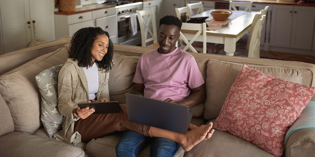 how to calculate a mortgage payment in Canada couple using laptop at home in natural light