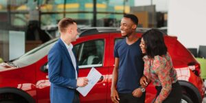 car loan payments in Canada — couple reviewing vehicle financing with a salesperson