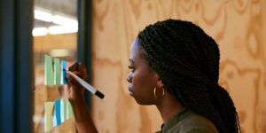 how to set financial goals — person writing goals on sticky notes during a planning session